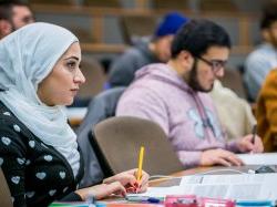 Photo of student in class taking notes.