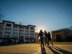 Photo of three students walking towards a building on campus