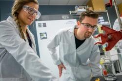 students watching as chemicals combine in beaker