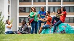 Photo of students standing, sitting and talking outside of Bohn Hall