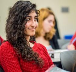 Photo of a smiling student sitting in a class.