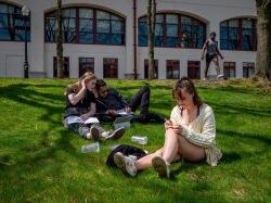 Students sitting on grass on campus