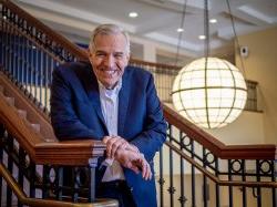 Rob Gilbert smiling on stairs