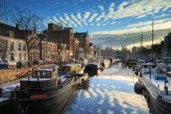 Ships and boats in a canal in Groningen, Noorderhaven, on a cold day in winter.