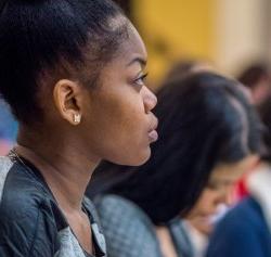 Photo of a student listening in a classroom setting.